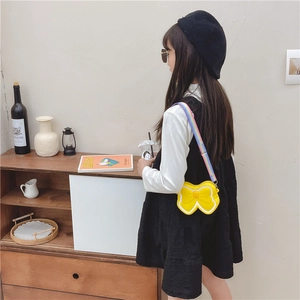 Cute yellow bow silicone crossbody bag for girls with a colorful rainbow strap