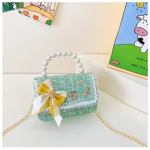Détail du sac pour enfants en tweed vert avec poignée en perles et breloque ourson mignon