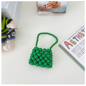 Dettaglio ravvicinato di una borsa mini per bambini in perline verdi fatte a mano