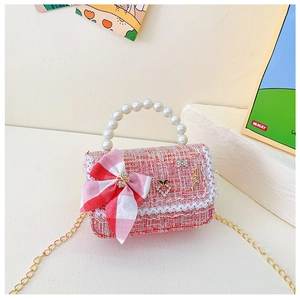 Détail du sac fille en tweed rose avec nœud, poignée en perles et chaîne dorée