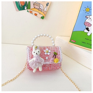 Detailansicht der rosa Tweed-Kindertasche mit Perlengriff und Spitzen-Hasen-Anhänger
