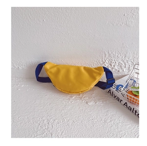 Détail d'un sac banane demi-lune jaune vif avec bandoulière en nylon bleu foncé