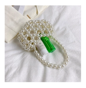 Dettaglio di mini borsa a mano in perle fatta a mano con elegante manico e finitura lucida