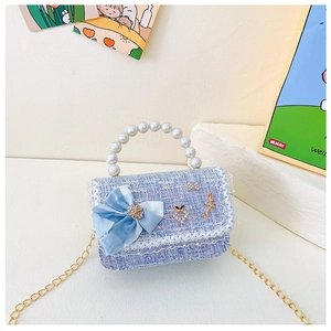 Détail du mini sac en tweed bleu clair avec nœud, perles et pendentif ballerine