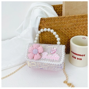 Detail of pink sequin crossbody bag for girls featuring pearl handle and flower decor