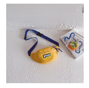 Détail d'un petit sac de poitrine jaune en toile pour enfants avec sangle réglable