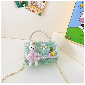Detail der grünen Tweed-Kindertasche mit Perlengriff, Plüschhase und Goldkette