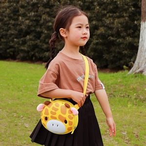 Cute yellow giraffe crossbody bag for kids featuring a 3D animal design on outdoor green grass