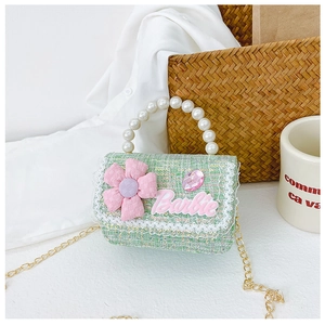 Detail of green tweed crossbody bag with pearl handle, pink flower, and gold chain strap