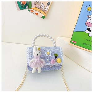 Detail der lila Tweed-Kindertasche mit Perlengriff und Plüsch-Hasen-Anhänger