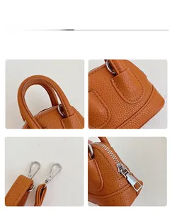 Detail of orange pebble leather mini handbag featuring silver hardware and crossbody strap