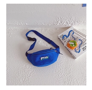 Détail du sac de poitrine en toile bleu roi avec sangle réglable et patch logo