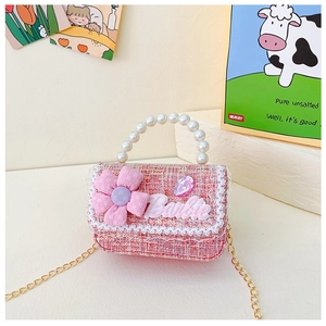 Detail of pink tweed toddler bag with pearl handle, floral decor, and gold chain strap