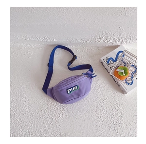 Détail de la banane en toile violette montrant la texture nylon et la sangle bleue réglable
