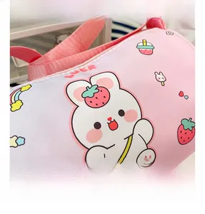 Detail shot of the pink cartoon girl's cylinder bag showing zipper and cute rabbit prints