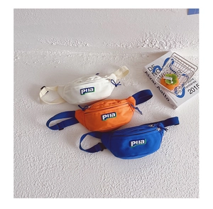 Vue détaillée de trois sacs banane en nylon pour enfants en blanc, orange et bleu avec sangle