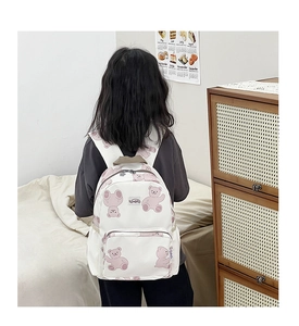 Rear view of child wearing the lightweight cartoon bear print backpack in a cozy room