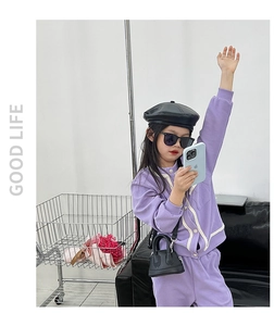 Close-up of stylish purple shell-shaped mini handbag for girls with white strap detail