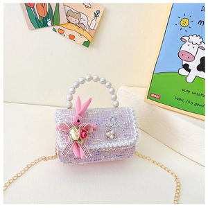 Details einer rosa Tweed-Kindertasche mit Perlengriff und Plüschhasen-Dekoration
