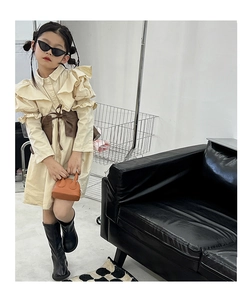 Fashionable girls ruffle dress in cream with brown bow belt and black boots