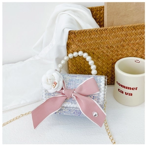Detail of tweed crossbody bag with pearl handle, camellia flower and ribbon bow