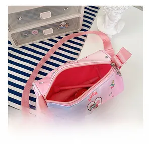 Detail showing the spacious interior of a pink cartoon strawberry cylinder crossbody bag
