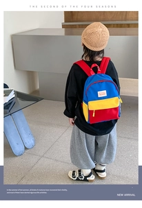 Detail of color-block canvas kids backpack with Tochaso woven label on girl's back