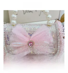 Detail of pink tweed girl handbag with pearl trim, large mesh bow and crystal drop