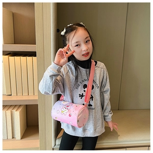 Detail of pink cylindrical canvas kid bag with cute bunny print worn by a young model