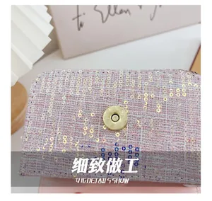 Detailed macro view of pink tweed fabric with sequins and a golden magnetic buckle clasp