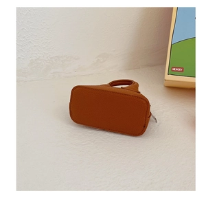 Detailed close-up of dark brown litchi pattern leather mini shell bag with metal zipper