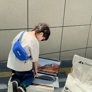 Enfant portant un sac de poitrine bleu en toile avec bandoulière réglable et logo stylé