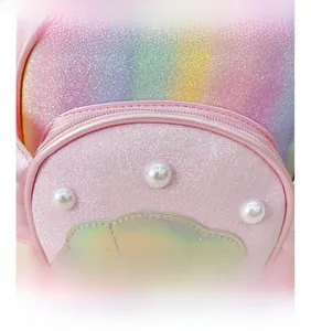 Détail d'un sac à dos rose à paillettes pour enfant avec perles et écusson de coquillage