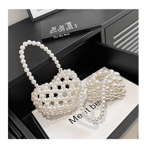 Dettaglio della mini borsa a mano con perle bianche e struttura a rete vintage