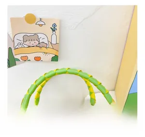 Détail du sac de plage arc-en-ciel montrant la poignée tissée main jaune et verte