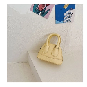 Detail view of mini lemon yellow shell bag with lychee grain texture and top zipper