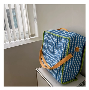 Detail of checkered children's storage bag with green piping and yellow straps