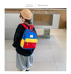 Rear view of a primary color contrast canvas backpack for toddler girls on model
