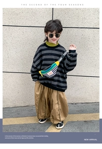 Detailed street style view of a kid stripe sweatshirt and khaki wide leg trousers set