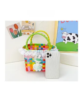 Détail d'un panier tressé coloré pour fille avec dentelle, lapin et téléphone pour échelle