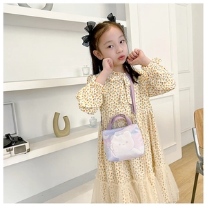 Fillette en robe fleurie portant un sac bandoulière en toile avec ours violet mignon