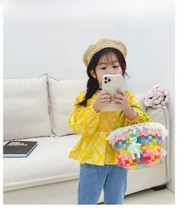 Détail du sac tissé coloré pour enfant avec bordure en dentelle blanche et poupée lapin