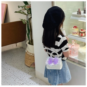 Detail of child wearing a princess style white bag with purple bow in a sweet cafe