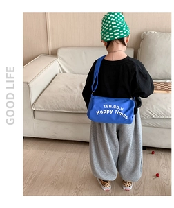 Détail du sac cylindrique bleu en toile pour enfants avec imprimé blanc et bandoulière