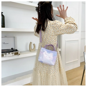 Fillette portant un sac bandoulière en toile avec ours sur une robe fleurie jaune
