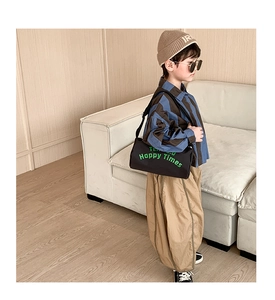 Détail de la sacoche bandoulière noire pour garçons avec imprimé et tenue tendance
