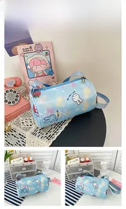 Detail view of children's blue cylinder crossbody bag with cute rabbit and strawberry prints