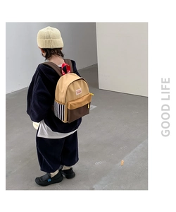 Detail view of children's color-block canvas backpack with striped design and top handle