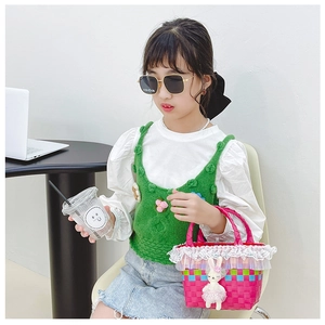 Détail du sac tressé rose avec bordure en dentelle et poupée lapin tenu par une petite fille