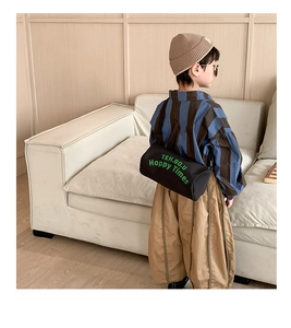 Détail du sac cylindrique noir en toile pour enfant avec imprimé de lettres vertes